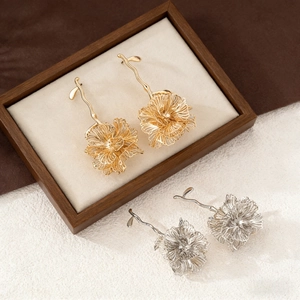 Macro detail of textured gold and silver metal flower petals on layered earrings