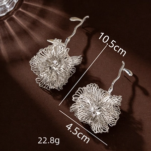 Silver woven flower drop earrings with multi-layered design and long metallic cascades