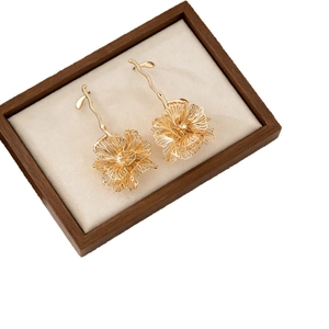 Elegant gold layered flower drop earrings with fine textured petals in a luxury display box
