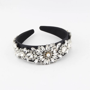 Close-up of baroque wide headband featuring sparkling crystal flowers and a pearl center
