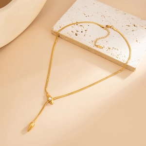 Detail of gold snake chain necklace featuring a zircon pendant and adjustable lobster clasp
