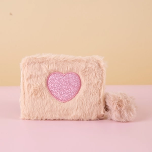 Detailed view of pink plush coin purse with glitter heart embroidery and pom-pom keychain