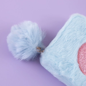 Macro shot of light blue plush bag with soft fur texture and pink sequin round patch detail