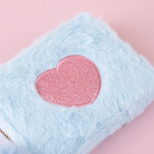 Close-up of light blue faux fur storage pouch with a glitter pink heart detail