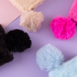 Macro shot of colorful plush coin purses in black, beige, pink, and blue with metal zippers