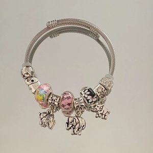 Close-up of beaded stainless steel charm bracelet with engraved elephant pendants