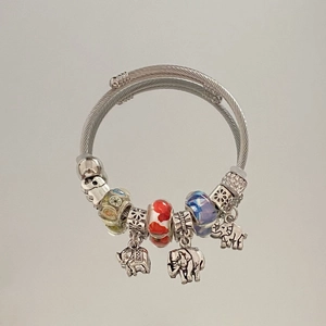 Detail of silver twisted cable bracelet with elephant charms and colorful glass beads