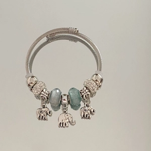 Detail of silver double-layered steel bangle with blue glass beads and elephant pendants