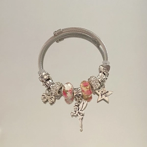 Detailed close-up of a silver charm bracelet with flower beads and forever star pendant