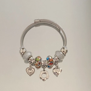 Detail of silver beaded bracelet featuring heart pendants and colorful glass charms