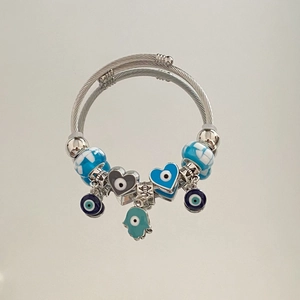 Detail of multi-layer steel bracelet with blue Hamsa hand and Evil Eye charms