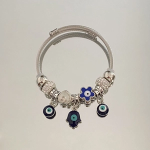 Detail of silver beaded bracelet featuring blue evil eye charms and Hand of Fatima pendant