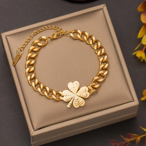 Luxurious gold titanium steel bracelet featuring a four-leaf clover pendant and bold links
