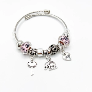 Zilveren kralenarmband met roze bedeltjes, olifant en hartjes hanger op witte achtergrond