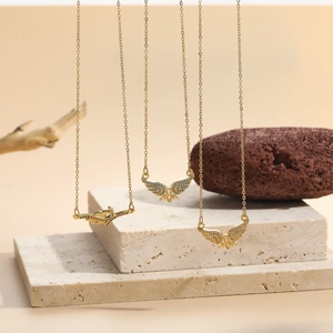 Detailed close-up of butterfly pendants with blue and white zircon on gold chain necklaces