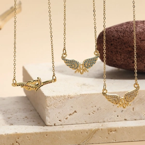 Three gold butterfly MUM necklaces with zircon stones on natural stone props