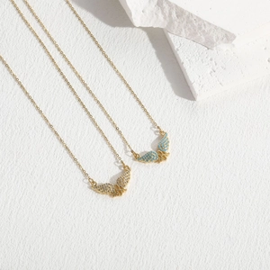Detail of gold MOM pendant necklace with turquoise stone and zircon on white stones