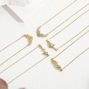 Golden butterfly and MOM heart necklaces set with colorful zircon on a white texture background
