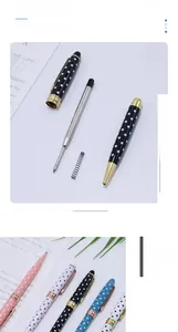 Disassembled view of polka dot metal ballpoint pen showing internal refill and spring