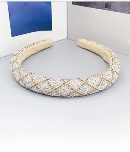 Detailed close-up of luxurious padded headband with white and AB rhinestones and gold thread