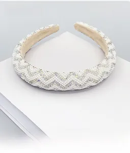 Detail of wide headband featuring white pearls and rainbow crystals in chevron pattern