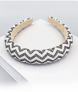Detailed view of padded headband with black and white rhinestones and wave pattern