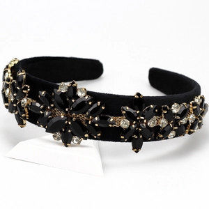 Close-up of black velvet headband featuring intricate gold flower rhinestone clusters