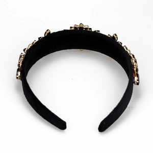 Detailed view of black velvet wide headband with gold claw-set rhinestones and crystals
