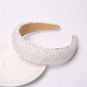 Close-up of luxury padded headband featuring full crystal beadwork on white ceramic tray