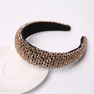 Macro shot of champagne crystal beads on a wide baroque headband with black inner lining