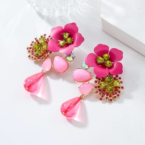 Macro detail of large resin flower earrings with pink petals and colorful crystals