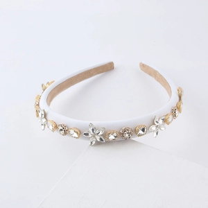 Elegant white padded headband with sparkling rhinestones and golden floral ornaments