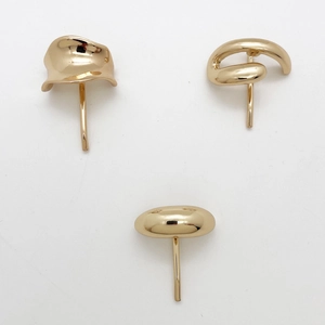 Close-up of three minimalist gold-finished metal hair hooks in wave and spiral shapes