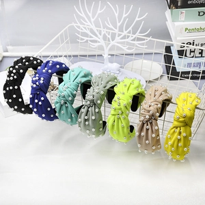 Knotted wide headbands with pearls in multiple colors like black, blue, and mint green