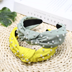 Detail of knotted fabric headband with white pearl accents in light green and yellow