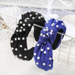 Detail of knotted wide headband with pearl embellishments and fine textured fabric