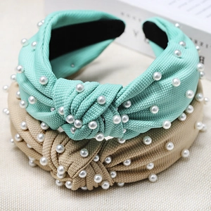 Detail showing knotted fabric headbands with pearls in mint green and apricot colors