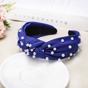 Detail view of navy blue knotted headband with white pearls and non-slip inner lining