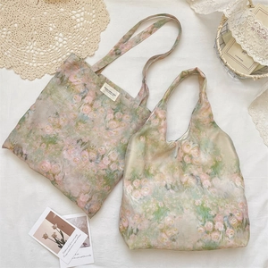 Dettaglio delle borse in chiffon con motivo floreale di rose rosa su fondo verde