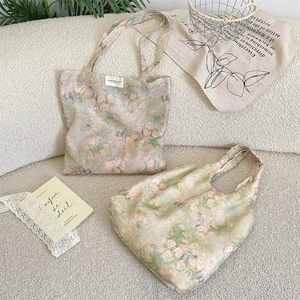 Dettaglio di borse in tela floreale con rose rosa posate su un divano beige