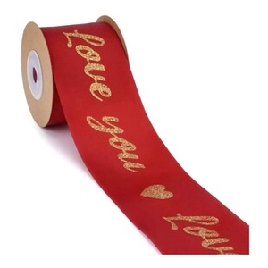 Detail of red satin ribbon with gold glitter Love You text and heart patterns