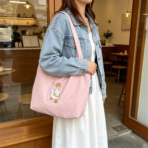 Detail of pink canvas tote bag featuring cute cartoon goose embroidery and drawstring closure