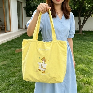 Bright yellow fabric tote bag featuring cute cartoon goose embroidery and wide handles