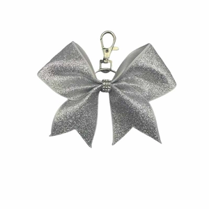 Close-up of sparkling silver sequin bow keychain with rhinestones and metal clasp