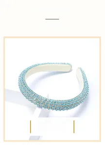 Close-up of sky blue Baroque headband with dense rhinestones on white display stand
