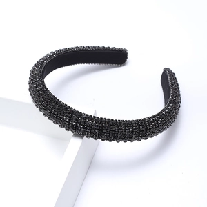 Baroque style thick headband with black rhinestones on a geometric stand