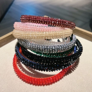 Elegant four-row crystal beaded headbands in various colors on a luxury jewelry tray