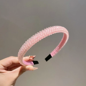 Close-up of pink beaded headband with sparkling crystals and protective black ends