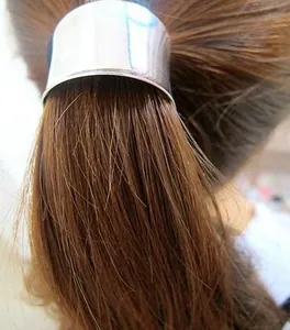 Close-up of a sleek silver metal ponytail cuff accessory on a hair bundle