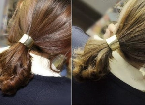 Close-up of a glossy gold metal hair cuff showing the mirror finish and ponytail fit